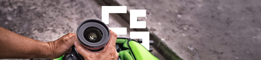 Someone pulling a DSLR camera out of a green camera bag