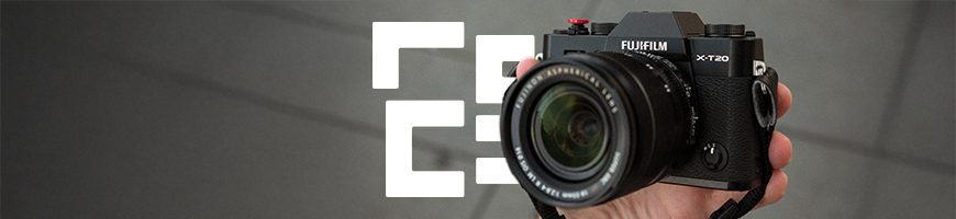 Person holding Fujifilm camera in front of pavement to show importance of camera insurance