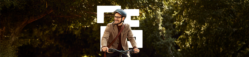 A smiling man riding a bike on a path in nature