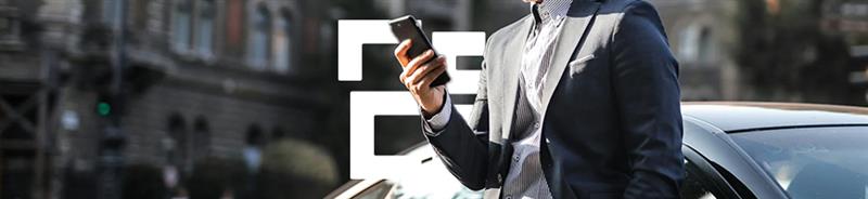 Man wearing suit leaning against a car looking at his smartphone for number of breakdown insurance provider