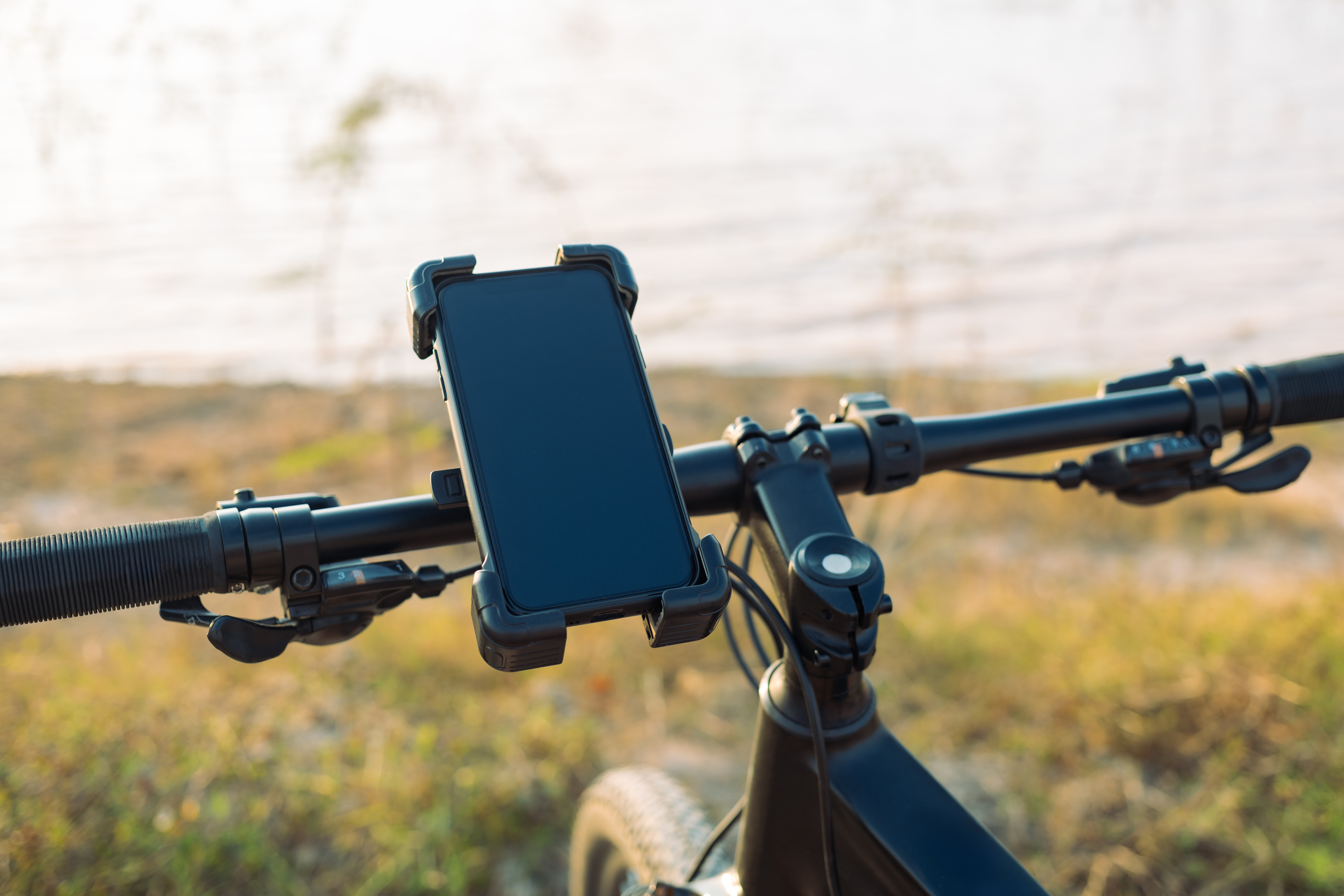 Close up of smartphone attached to bicycle handlebars by a phone mount