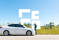 Woman stands on the roadside in front of a white car with the bonnet open under a blue sky thankful for single trip European breakdown cover