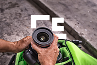 Person pulling a DSLR camera out of a green camera bag