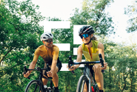 Two people enjoying a bike ride along a wooded path