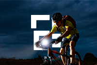 A man pedaling a bicycle in the dark with a bright light to highlight nighttime cycling safety