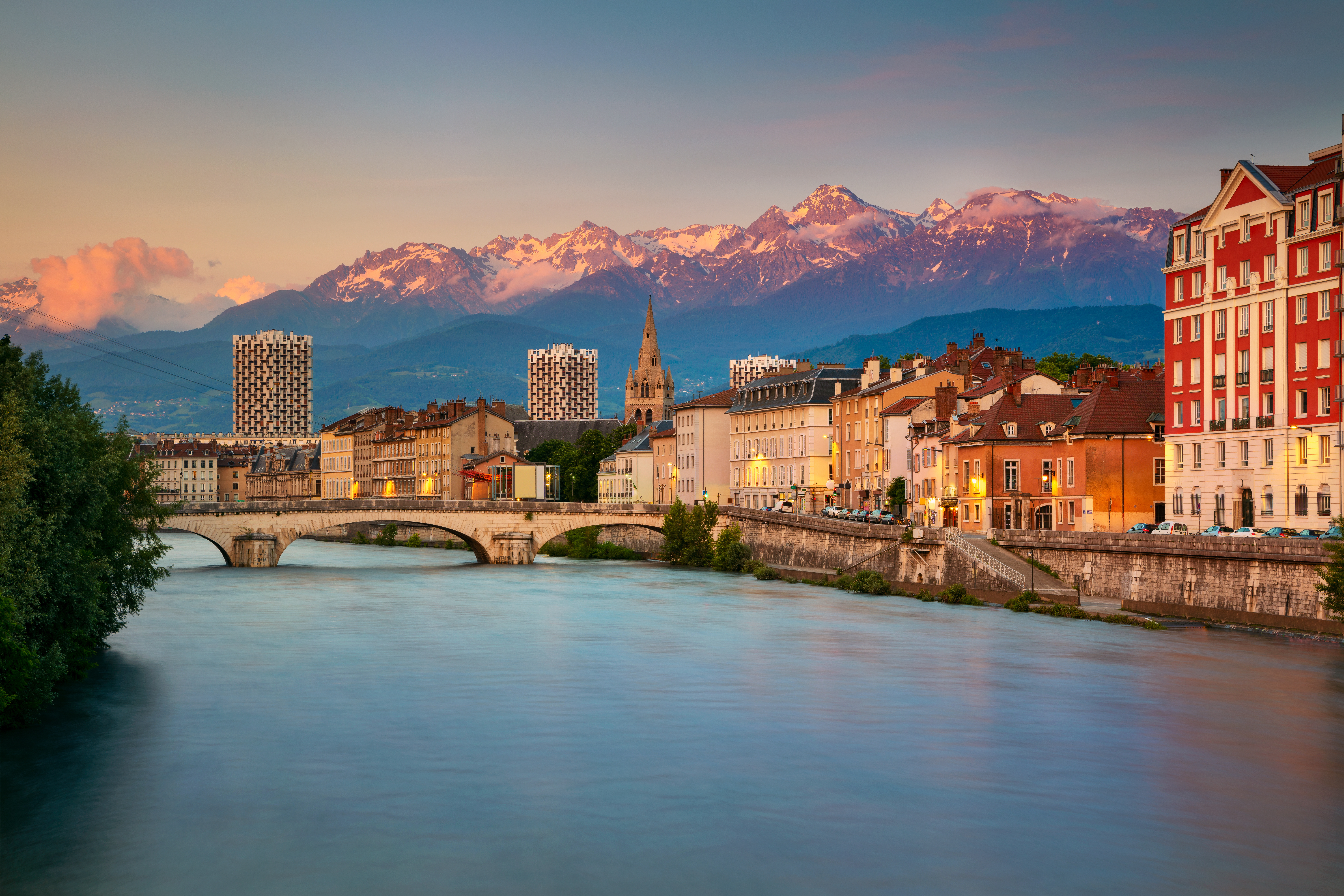 Cityscape of Grenoble in France at sunset with the mountains in the background
