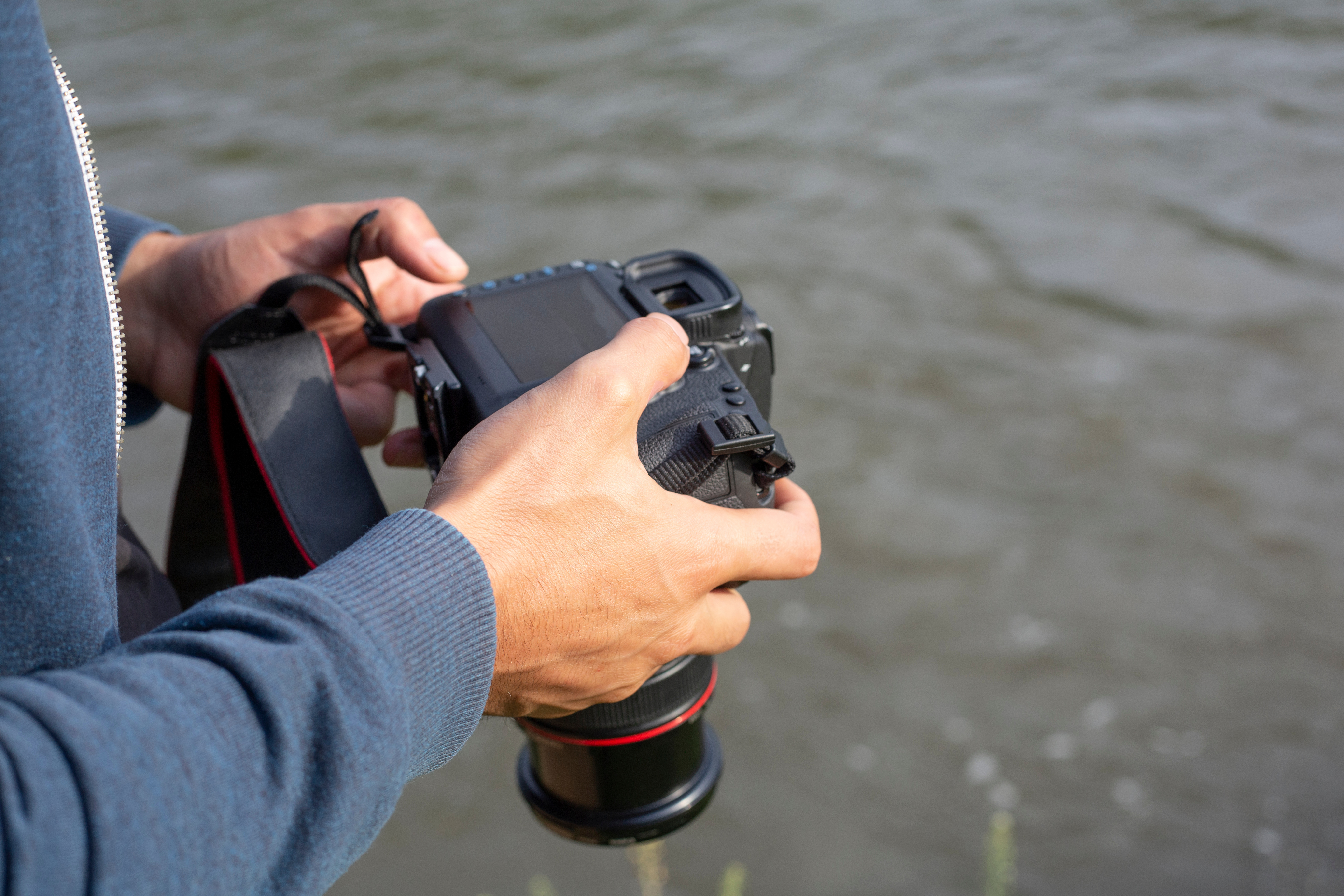 Person checking the LCD screen on their DSLR at the beach