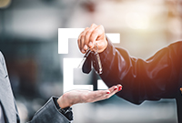 A hand gives car keys to the open hand of the person renting a car.