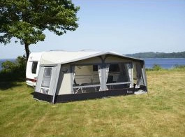 Isabella Ambassador Dawn caravan awning attached to side of touring caravan parked in a green grassy field