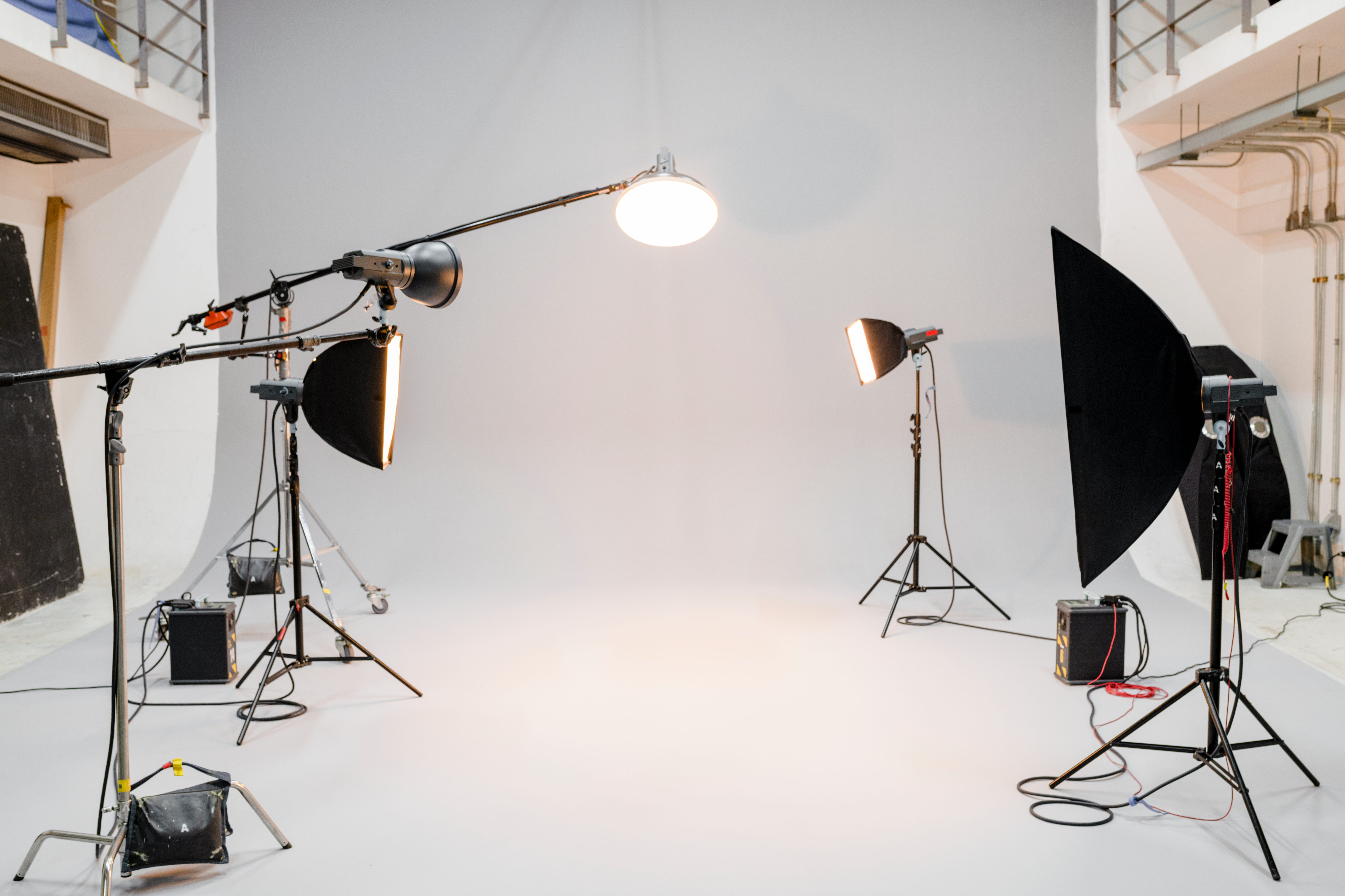 All white photography studio with five lamps all turned on producing a lot of heat
