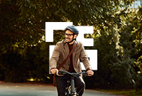 A smiling man riding a bike on a path in nature
