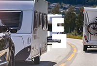 A black car towing a caravan on a main road