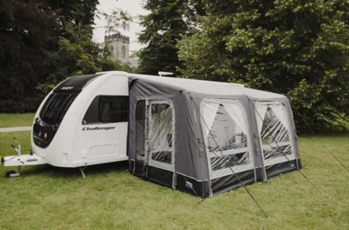 Vango Balletto caravan awning attached to side of touring caravan parked in a green grassy field