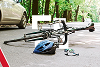 A broken down bicycle lies next to a silver car with a red warning triangle on the roadside